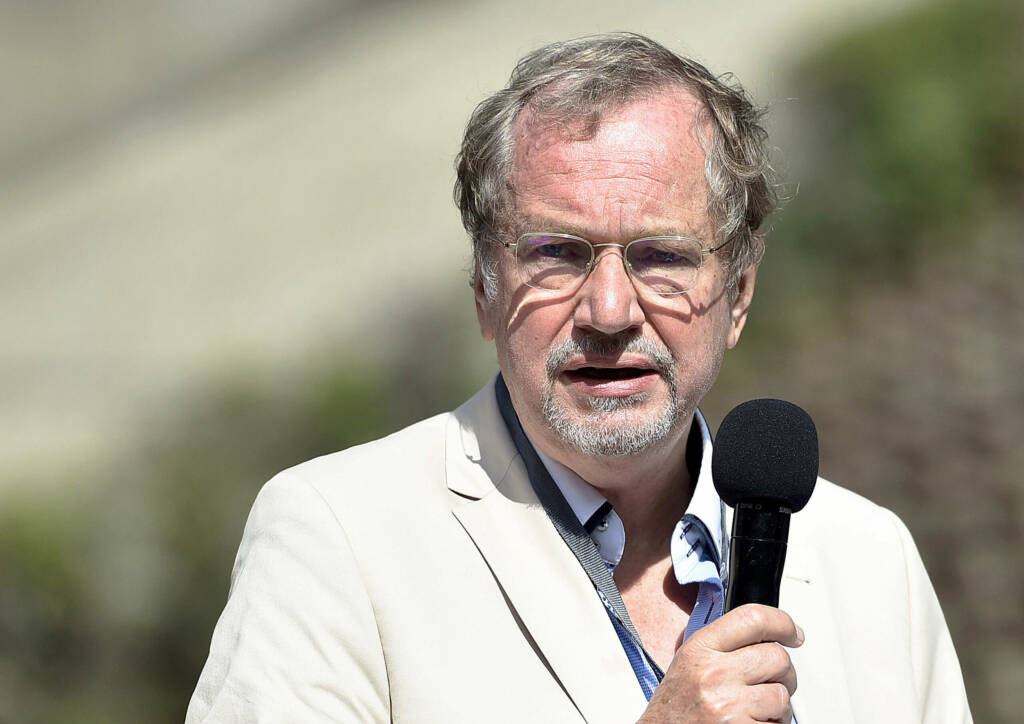 Prof. Jens Michow abgebildet mit einem Mikrofon